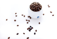 A Cup of Coffee Bean and Some Coffee Bean on a White Background